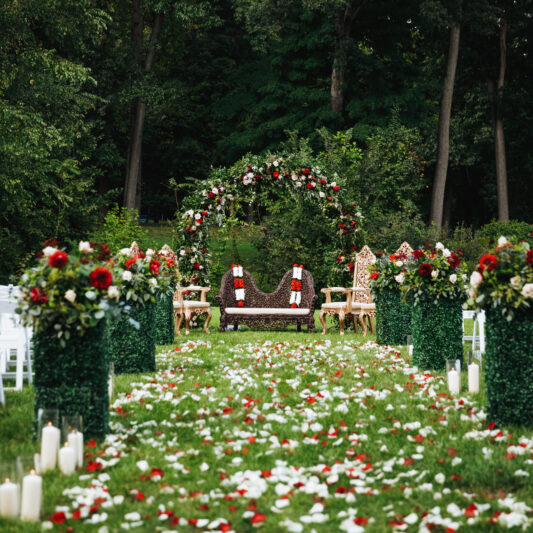 Rose petals cover green garden ready for traditional Hindu wedding ceremony